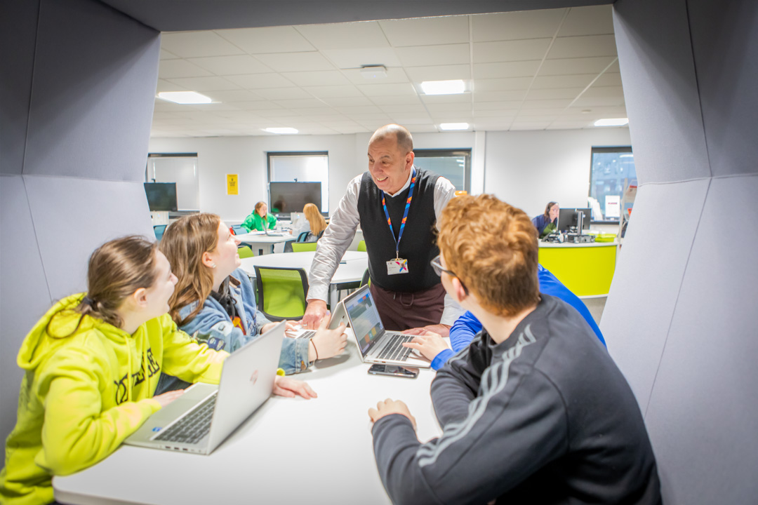 Staff member supporting students during a group study session in the Easterhouse Flexible Learning Centre at Glasgow Kelvin College.