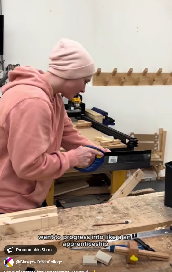 Rachael, Women into Construction student, measuring timber with a handsaw in a workshop at Glasgow Kelvin College.