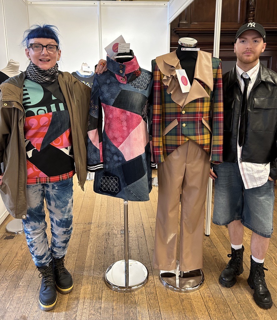 Glasgow Kelvin students Evy Craig and Craig Watson standing proudly beside their award-winning fashion designs at Craftex 2025.
