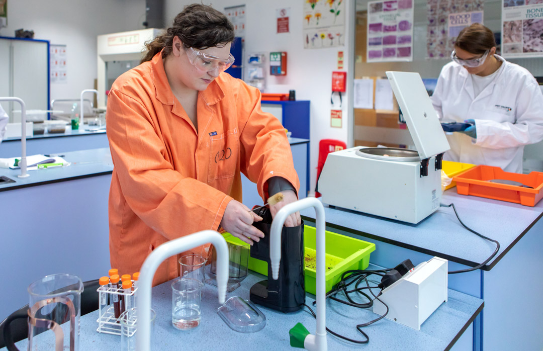Student using lab equipment with centrifuge in science lab during practical session