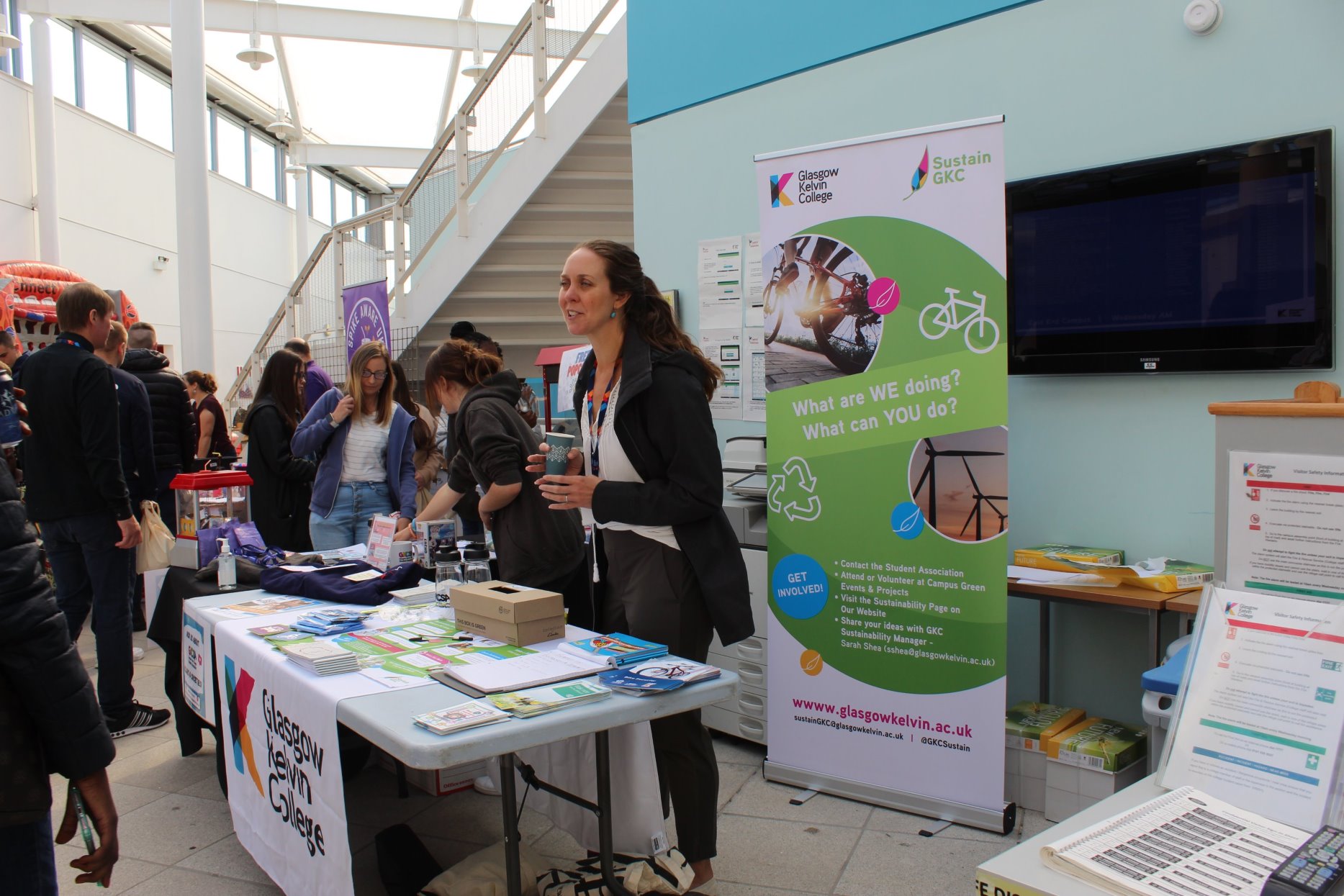 Glasgow Kelvin College sustainability stall at Freshers’ Week, featuring a banner, leaflets, and staff engaging with students about green initiatives.