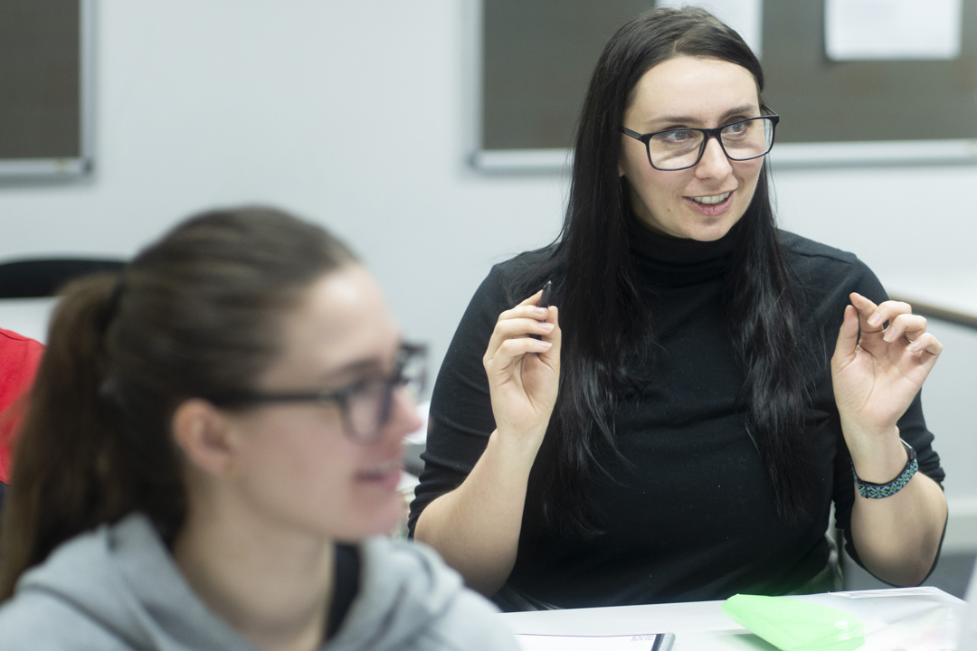 Student raises a point during an engaging discussion in a classroom setting.