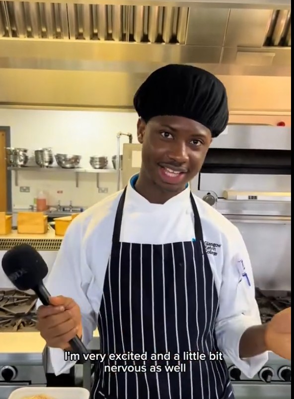 Hospitality student Mohammad speaking into a microphone while standing in a professional training kitchen at Glasgow Kelvin College.