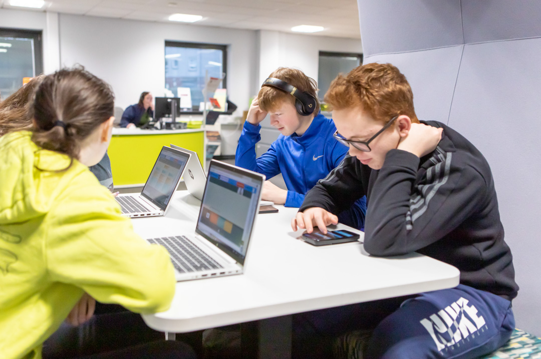 Group of students working on laptops and mobile devices in the Library and Flexible Learning Centre at Glasgow Kelvin College’s Easterhouse Campus.