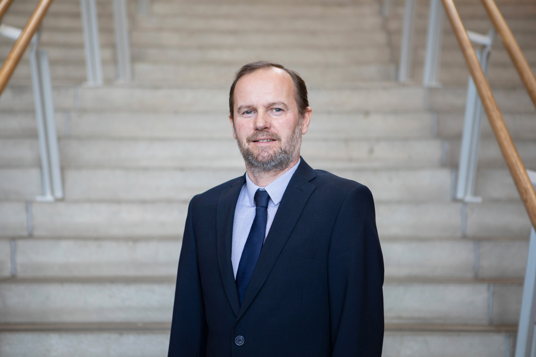 Robin Ashton, Vice Principal of Curriculum and Quality Enhancement at Glasgow Kelvin College, standing on an internal staircase in formal attire