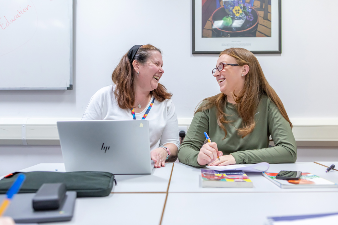 A cheerful moment between lecturer and student at Glasgow Kelvin College, showcasing supportive relationships and engaging one-to-one learning.