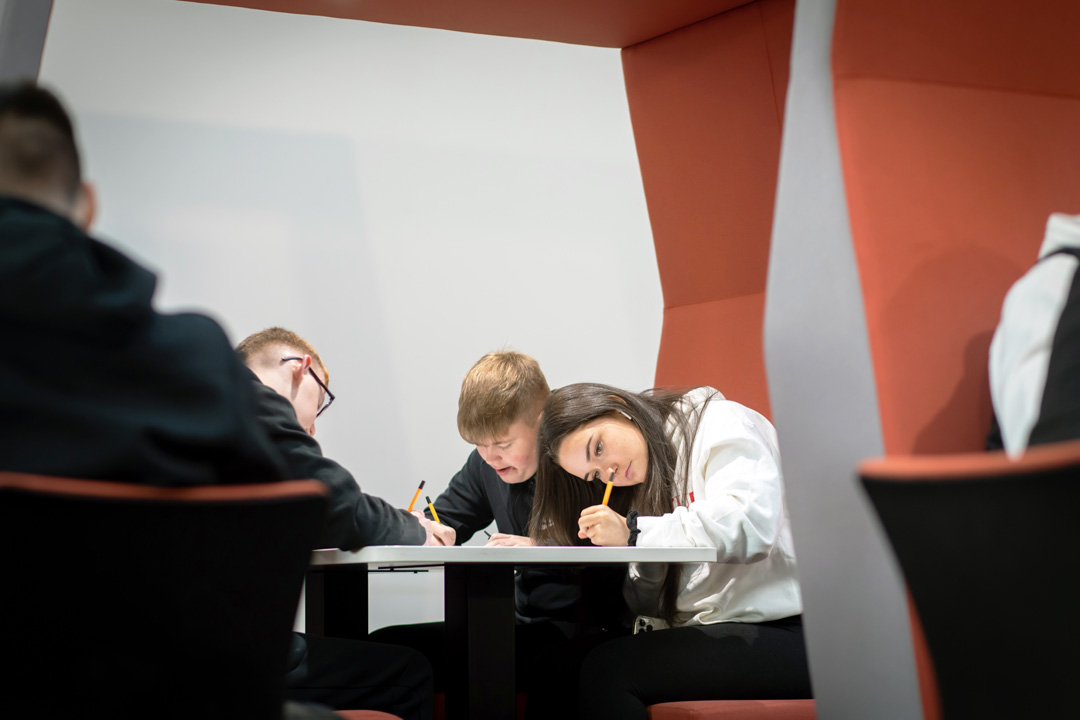 Students gathered in a pod seating area at Glasgow Kelvin College’s Springburn Campus, working collaboratively with laptops and study materials.